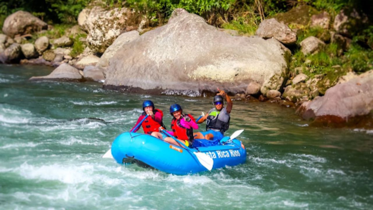 Group of adventurers rafting through river rapids in Costa Rica.